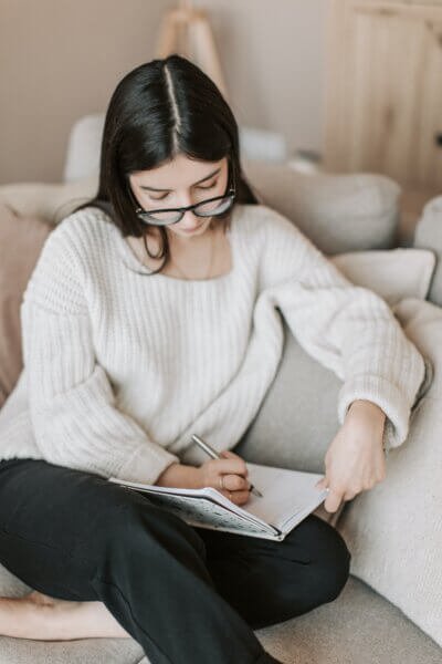 une jeune femme qui écrit dans un journal de gratitude