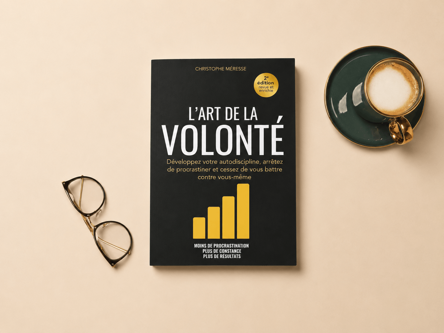 L’Art de la volonté posé sur une table, accompagné d’une tasse et de lunettes